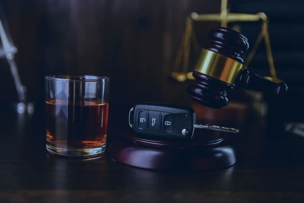 Whiskey with car keys and handcuffs. Concept for drinking and driving